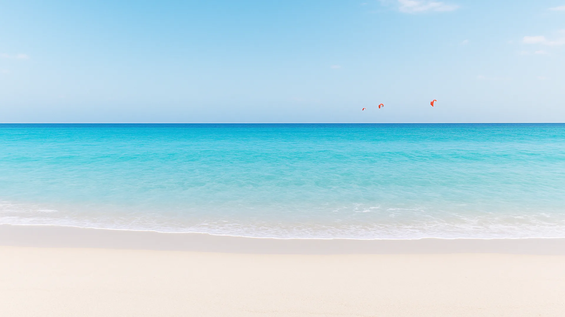 Plage méditerranéenne à l'eau turquoise avec des ailes de kitesurf au loin